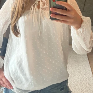 Vit blus - Jättesöt vit blus med prickigt på armarna. Den är från Vila i strl 34. I superbra skick och har bara användts några gånger.