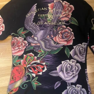 Christian audigier hoodie  - Säljer denna Christian Audigier hoodie i strl M bra skick!🕷️ kan sitta Baggy på S, en del av dragkedjan är av men går fortfarande att dra upp. Sällsynt och snygg zip kofta! Kontakta för fler bilder, använd köp nu🖤