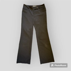 Lågmidjade randiga kostymbyxor - Ett par fina utsvängda randiga kostymbyxor som tyvärr inte passade mig, därav inga bilder på. De är lågmidjade. Fin detalj vid knäppningen där det finns två små blommor.