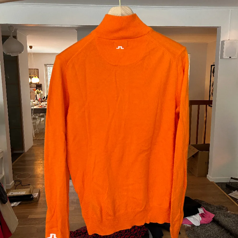 Halfzip pullover i skitsnygg orange nyans från j.lindeberg. Storlek m för herr, oanvänd.. Stickat.