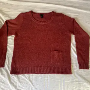 Stickad tröja från h&m i 100% akryl. Färjen är röd/orange  Längd: 58 cm Bredd: 54 cm Armlängd (från axelsömn): 63 cm