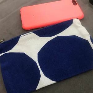 Marimekko small purse cosmetic bag  - Marimekko textile bag with zip  Of very thick material  Patter name Kivet the phone next to it is smaller iPhone 