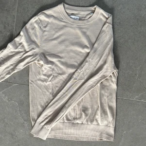 These Glory Days Tröja - Beige Crewneck Tröja från Volt som jag inte har användning av längre. Den är i användbart skick men har hål i armhålorna som jag fixat se bild 3. Pris inte fast.