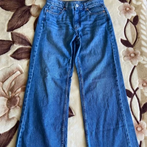 Nya mörkblåa vida jeans från Kappahl - Otroligt sköna och bekväma jeans i mörkblått med vida ben, från Kappahl. Nya och oanvända pga för liten storlek. Äkta denim-ingen stretch. Mid-waist. Stl:38. Nypris: 599 kr  MÅTT Totallängd: 106,5 cm Stuss/höfter: 51 cm Innerbenslängd: 82,5 cm 