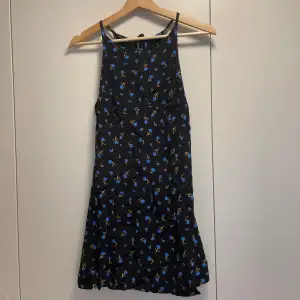 Kort klänning från Bershka! Säljer då den är för liten. Fint skick🌟 Svart med blå blommor på💙 Storlek 36