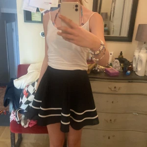 Snygg svart kjol med vita ränder på - Den är i jätte bra skick och endast använd 4 gånger. Den har inga skador alls. Jag säljer för att den är för liten och för att de inte är min stil längre💗