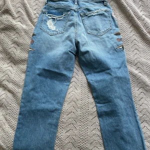 Jeans med fina blomdetaljer - Aldrig använda jeans med prislappen kvar.