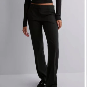 Lågmidjade kostymbyxor  - Ett par snygga lågmidjade kostymbyxor ifrån Nelly. Bra skick bara lite noppriga. Storlek 36