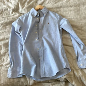 Ralph Lauren skjorta  - Här säljer jag en skit snygg Ralph lauren skjorta i färgen ljusblå. Den är i 10/10 skick aldrig använd. Den är perfekt nu till sommaren. Om det är några frågor eller funderingar är de vara att höra av sig. Mvh north-resell 