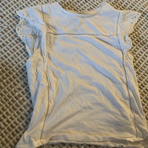 topp - Vit topp med spets/broderi detaljer. Säljs inte längre på H&M. 