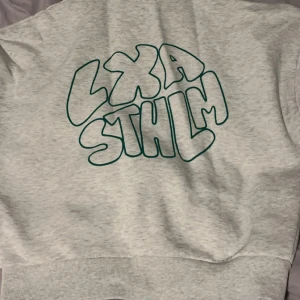 LXA hoodie  - Säljer du denna sköna gråa LXA hoodie med grön text på ryggen. Storlek xs men mer som s då jag som är 180 nästan fortfarande kan använda den. Blivit lite nopprig annars i bra skick!