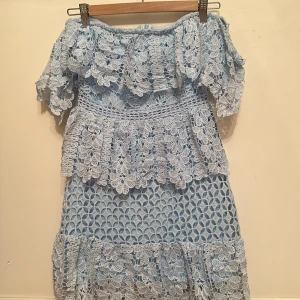 Ljusblå boohoo klänning - Säljer denna väldigt fina korta ljusblåa klänning med blommig brodyr och off shoulder armar i storlek UK 8/ EU 36
