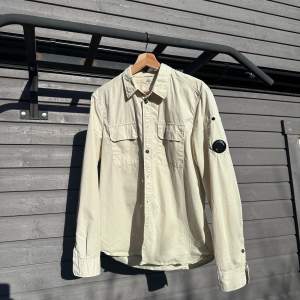 CP company Lens-overshirt Storlek Large Fin beige färg, perfekt för en sommarkväll! Knappt använd, väldigt fint skick 