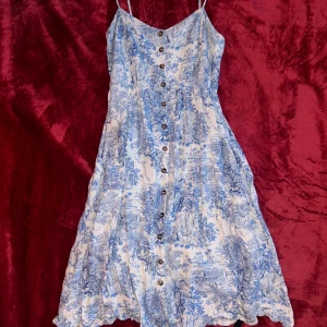 Lång klänning, blå/vit - Blå/vit lång klänning med knappar på framsidan. Spagetti straps.