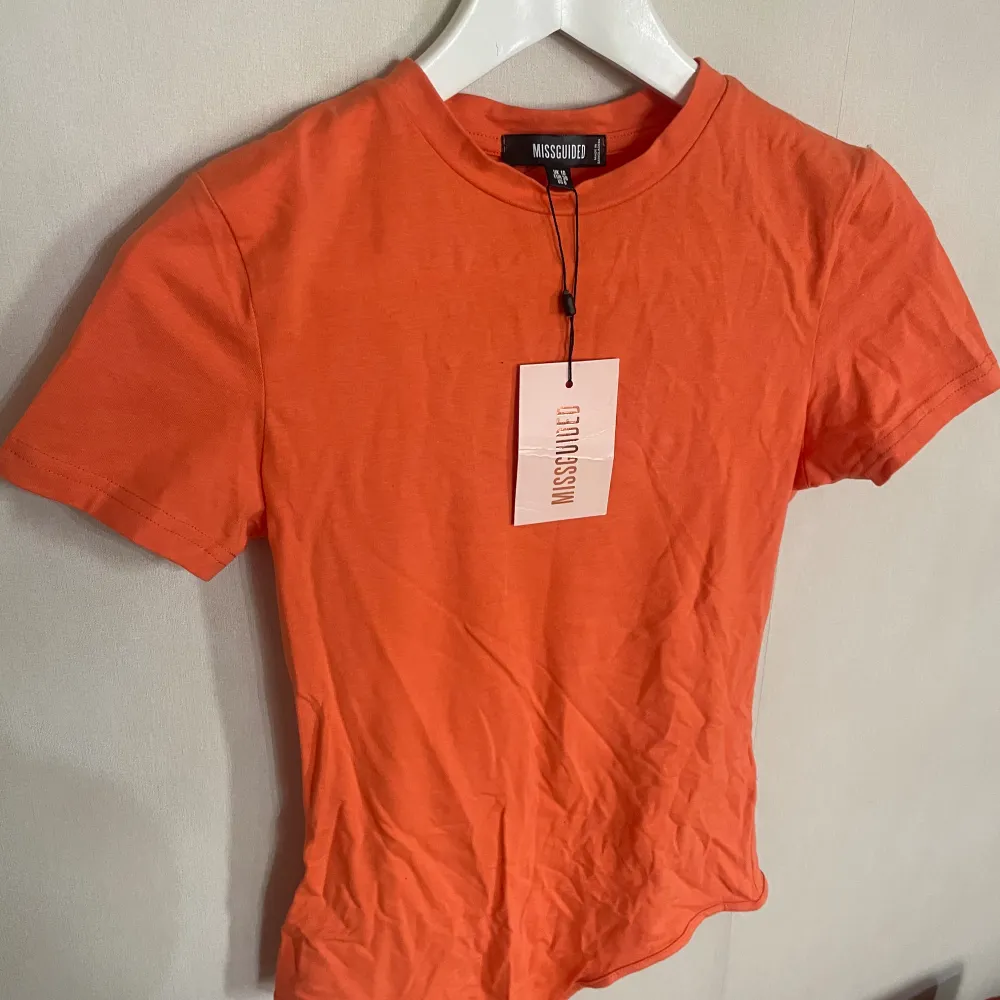 En orange bodysuit perfekt inför sommaren. Helt ny från missguided!. T-shirts.