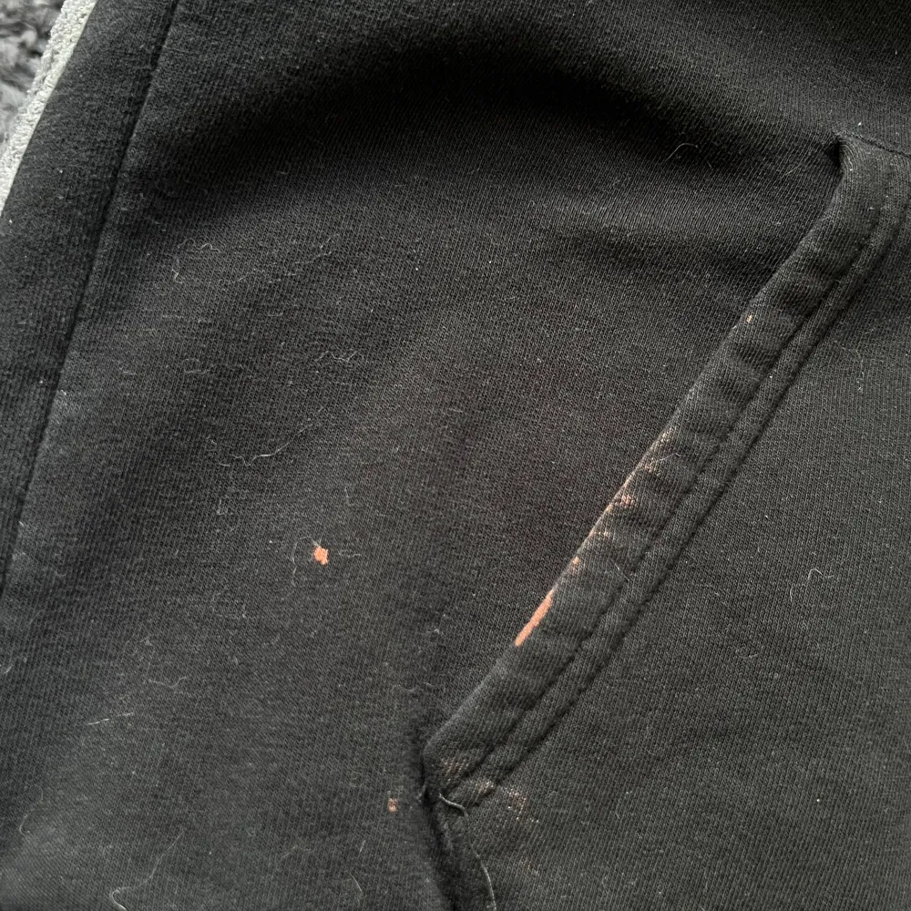 Svart hoodie myck rött tryck fram, har fått lite färg på vid fickan Står xs men tycker mer den är s/m. Hoodies.