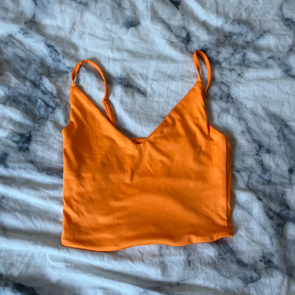 Jättesött oranget linne från NeyYorker i jättebra material. Den är väldigt kort och aldrig använd!. Toppar.