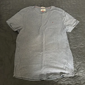 Tommy H/J T-shirt - T-shirt från Tommy jeans eller Tommy hilfiger i en fin blå färg (inte grå, skicka för fler bilder). Knappt använd då den sitter dåligt, skick 9.5/10. 