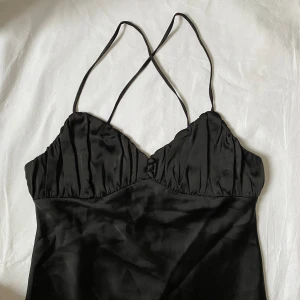 Svart v-ringad Zara klänning - Elegant svart klänning i mycket bra skick. Klänningen är av ett tjockt silkeslikt material och faller till knäna.  