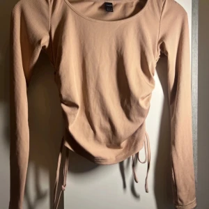 Croppad tröja  - En oanvänd Croppad tröja med snören på sidorna som går och spänna åt