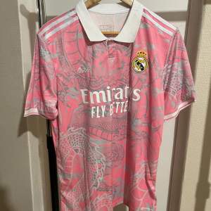 Helt ny och oanvänd Real Madrid fotbollstshirt. 10/10 skick. Riktigt snygg och passar perfekt till sommaren!