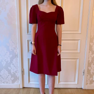 Vinröd klänning, Emmy design  - Jättefin vinröd klänning i skönt material. Storlek 38.  Modellen på bilden är 173 cm och har storlek 38 i de flesta andra kläder. Aldrig använd. Vi har lagt ner vår klänningsbutik och säljer ut. Ny pris är 2000-3000kr