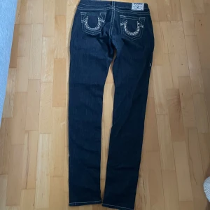 Lågmidjade trueys med snyggt tryck - Lågmidjade trueys med ett glittrande tryck på bakfickorna Pruting är såklart tillåtet Ytterbenslängd: 110cm Midja: 39cm Benöppning: 16cm Modell: 168 cm