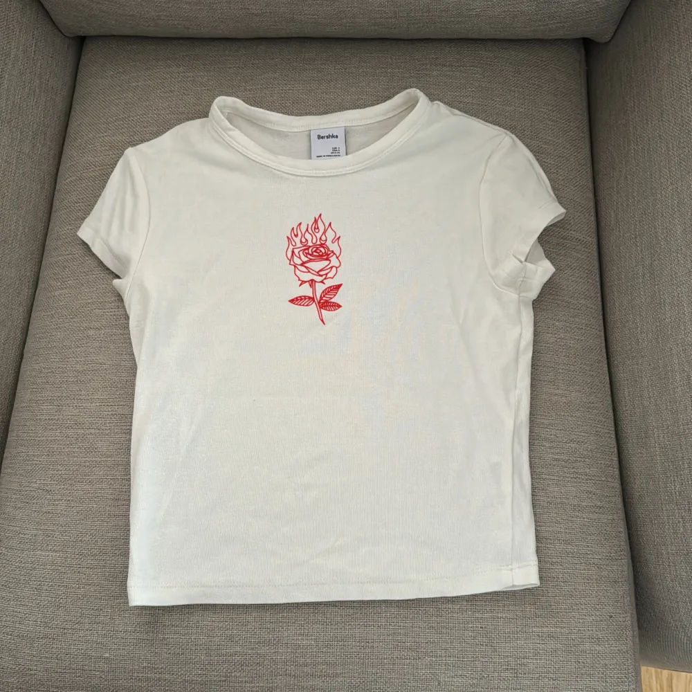 En fin t-shirt med en röd ros på🎀 köpte den från Bershka och har använt den 2-3 gånger 💗. T-shirts.