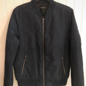 Marinblå bomberjacka - Skitsnygg bomber jacka som tyvärr är för liten på mig! Det är marinblå, men ser ut att vara svart på annonsen. 