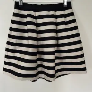 Randig kjol i svart och cremevitt Storlek: 34 Märke: H&M, Material: 61% viskos, 24% polyester, 15% polyamid Skick: Inga anmärkningar