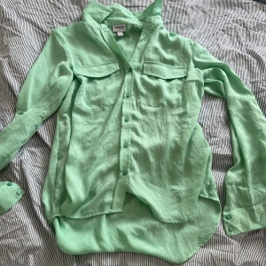 Oanvänd grön skjorta! - Otroligt fin ljusgrön färg och otroligt mjukt material! Den går ner lite längre över rumpan. Skjortan är tunn och bra till vår/sommar!❤️