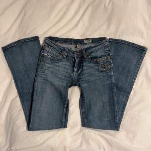 Lågmidjade jeans i utsvängd modell. Midja: 76cm innerbenslängden: 80cm