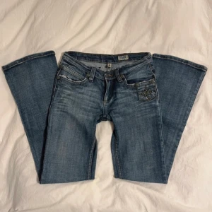 Lågmidjade utsvängda jeans - Lågmidjade jeans i utsvängd modell. Midja: 76cm innerbenslängden: 80cm