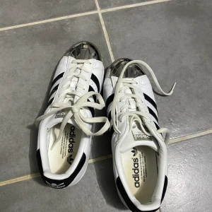 Adidas superstar, allstar!  - Nästan helt nya allstar, har använt enstaka gånger. Men för stor storlek för mig. Den är i storlek 39. En design som är svår att köpa. Är helt rena och typ inga märken på att de är använda! Svartvita med blank snäcka. Passar till alla outfit. 
