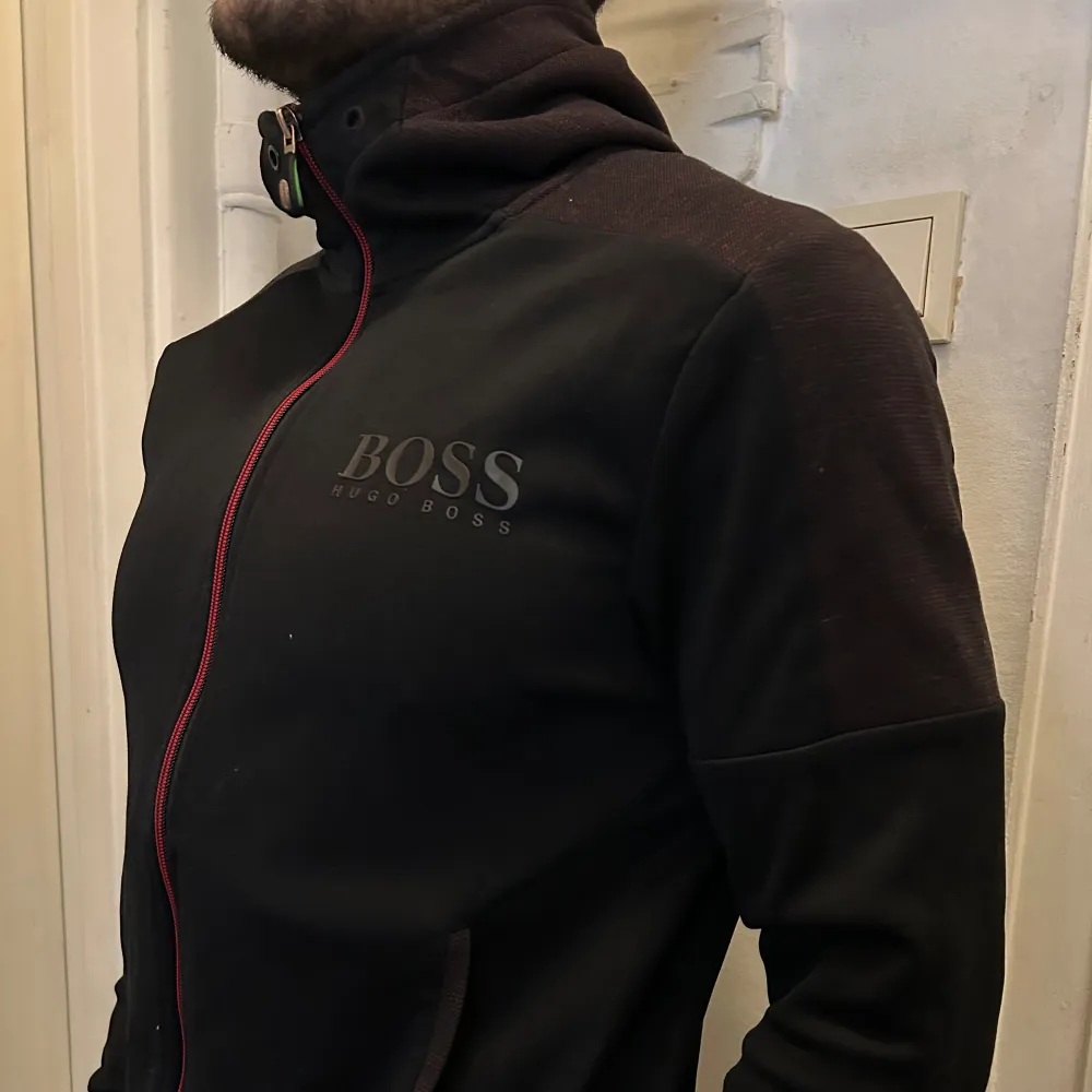 Snygg svart/röd hoodie från Hugo Boss till salu. Knappt använd. Passar S och M.  . Hoodies.