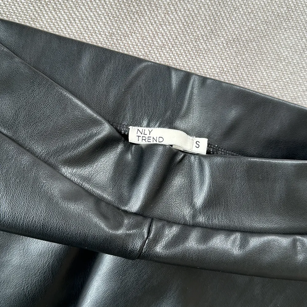 Säljer dessa snygga byxor i fakeskinn. Längre utsvängda med slits vid utsidan av byxslutet.. Jeans & Byxor.