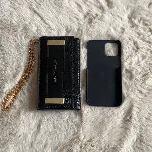 iPhone 12 mini skal - Ett svart iPhone 12 mini skal. Skalet har guld detaljer och på insidan kan man lägga sina kort. Man får även med ett magnet skal som är helt svart. Aldrig använt eftersom jag beställde fel storlek. Det är i fint skick. Köparen får stå för frakten.💕