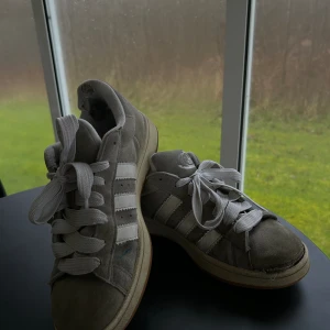 Adidas campus gråa  - Storlek 44 på adidas campus. Köpta mars 2023.  Skicket slitet/använt.  Säljs för 199kr istället för att slängas. Fixar man framsidan och byter suvla på insidan blir det som nya ungefär igen.  Nypris just nu runt 1599kr.