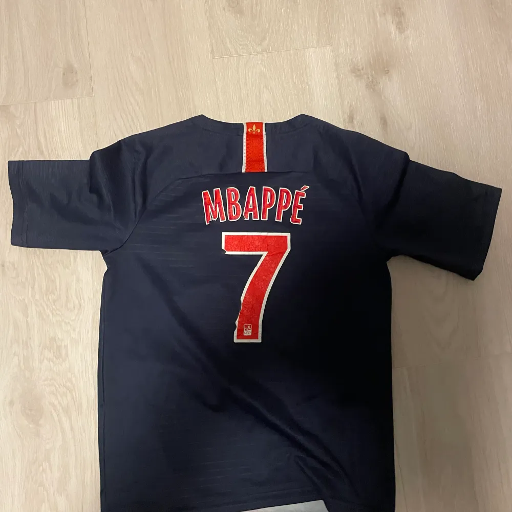 En Kylian Mbappe tröja från hans första säsong i PSG! Tröjan är i okej skick. Strl 164. T-shirts.