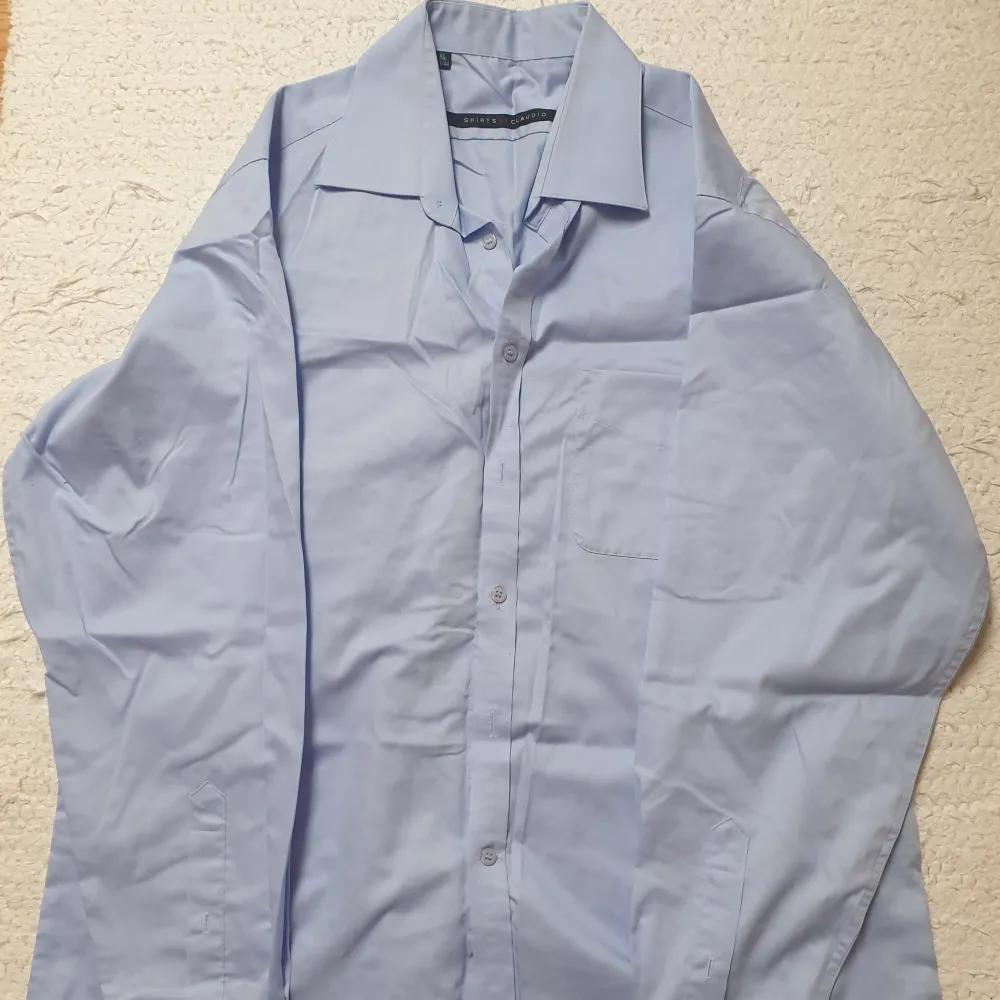 Ljusblå skjorta i XL. Det finns 2 st likadana, en skjorta för 15 kr, båda skjortorna för 20 kr. Kan skicka fler bilder och tänka mig sänka priset. Hör av dig vid intresse!. Skjortor.