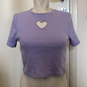 En lila t-shirt med hjärta i mitten  De står M men den är lite taight om man har större bröst