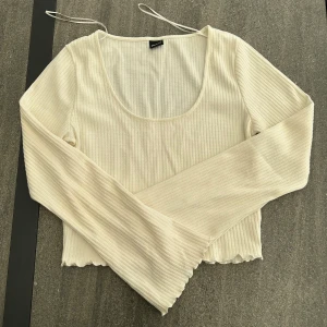 Vit topp med långa utsvänga ärmar  - Gina Tricot 