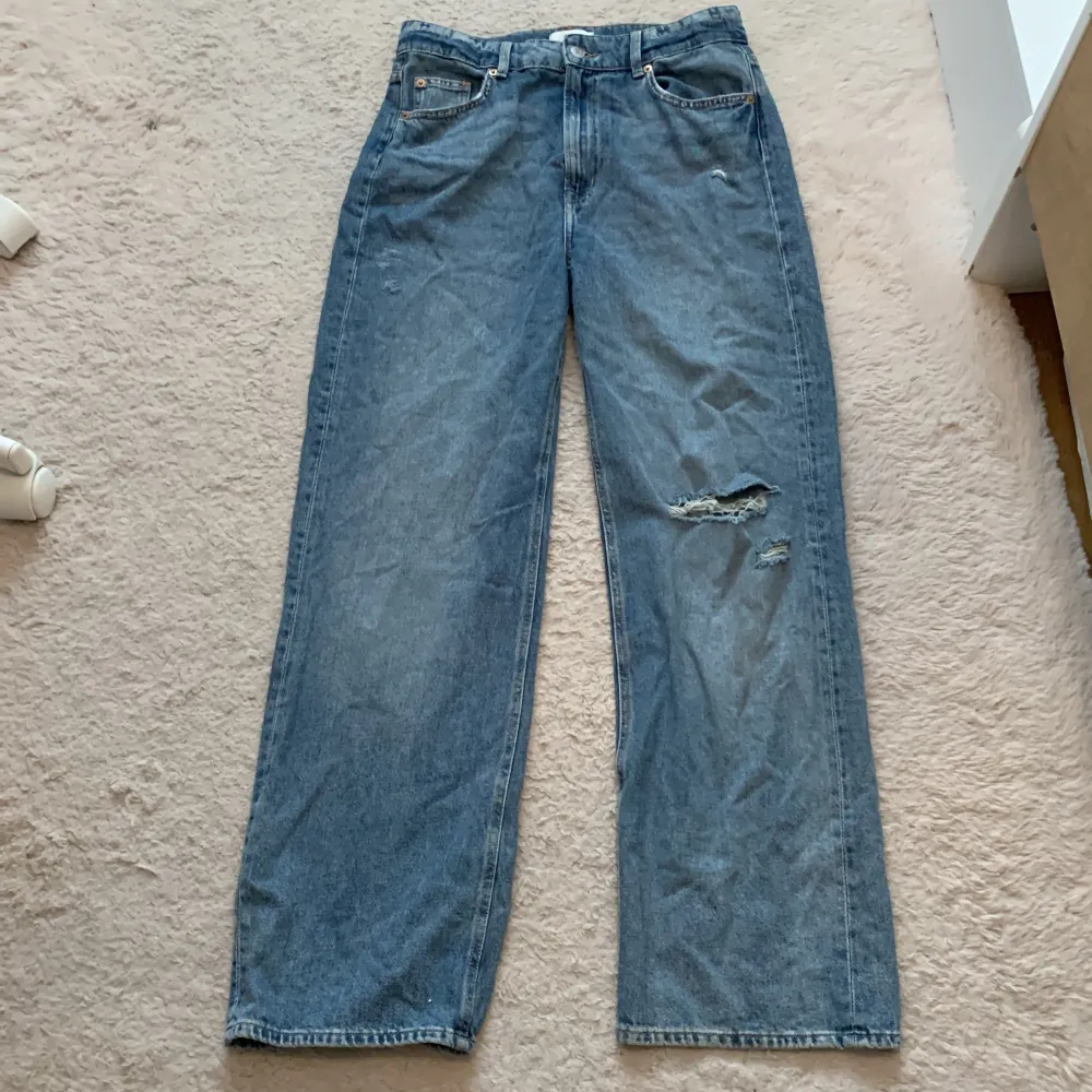 Ett par blåa jeansbyxor från H&M i storlek 42. Byxorna har en avslappnad passform med slitningar på ena benet👖👌🏼💞. Pris går att diskutera💸    Hör av er!💕 . Jeans & Byxor.