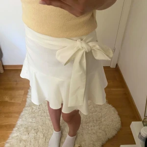 Kjol - Vit/kräm kjol köpt från Sellpy med lappen kvar, originellt från Zara! Roset knytning och volang💕