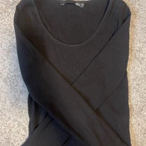 Svart ribbad långärmad topp  - Svart långärmad topp från lager 157. Brukar bära storlek S och denna passar bra. Finns även i vit.