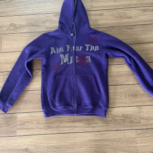 Rhinestone zip - Aim for the moon zip i storlek M. Använd en gång sedan gick dragkedjan sönder. Mycket fint skick men dragkedjan behöver lagas.