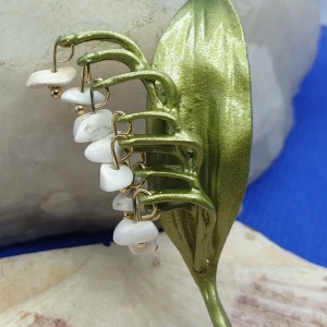 Brosch - Underbar Liljekonvalj med vita ädelstenar som blommor (vit turkos) - Den här broschen föreställer en liljekonvalj måtten är ca 6.5 ×3.5 cm. Grön emaljerad metall med vacker ytstruktur med vita ädelstenar, vit turkos, som hänger iform av blommor. Otroligt vacker brosch.