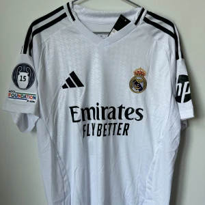 Mbappé Real Madrid Hemmatröja 24/25 - Oanvänd Real Madrid Hemmatröja för år 2024-25 i storlek M. Namn på tröjan är Mbappé och nummer 9.