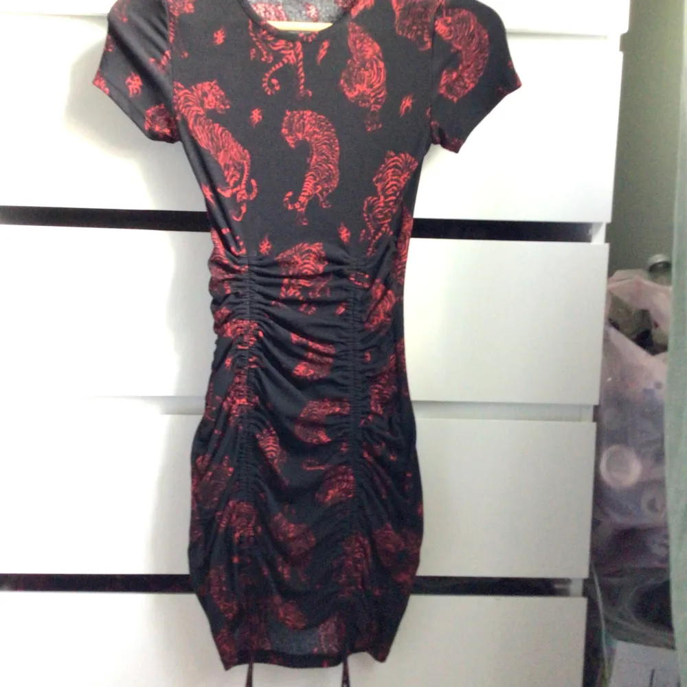 Svart och röd klänning med tigermönster och snörning som går att justera från h&m. Klänningar.