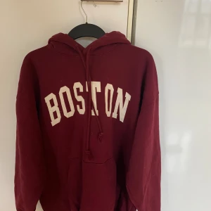 Boston Hoodie - Skön ocersized hoodie från brandy med ”Boston” tryck. Fin röd färg och skönt material! 
